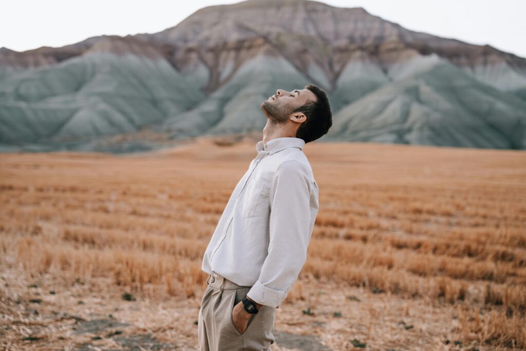 Man in Shirt Standing with Eyes Closed on Field